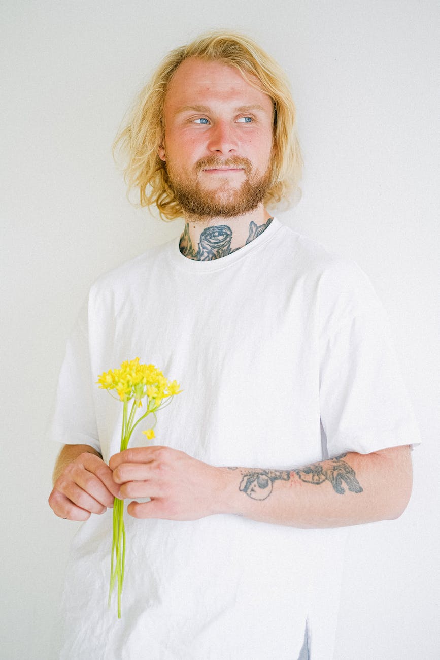 dreamy hipster man with blooming flowers in daytime